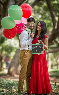 a man and woman pose for a photo with balloons in front of their faces, holding a sign that says save the date