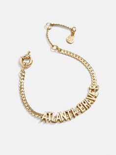 a gold bracelet with the word happy written on it and a chain attached to it