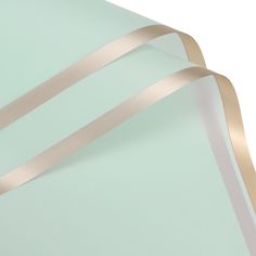 a close up view of the side of a light green wall with gold ribbon on it