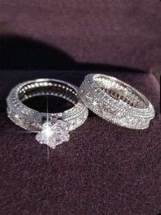 two diamond wedding rings sitting on top of a purple cloth with the words, i do not know what they are