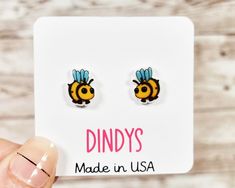 Embrace the cuteness with our 'Adopt Me' Bee stud earrings -- the perfect birthday gift for girls who adore adorable animals! These cute animal earrings not only showcase a lovable sloth design but also carry the heartwarming message of adoption. Delicately crafted, these stud earrings make for charming and meaningful birthday gifts. The 'Adopt Me' Bee Stud Earrings are not just accessories; they represent the spirit of giving and love. Whether you're looking for adopt me birthday gifts for girls or unique birthday favors, these earrings are a delightful choice to add a touch of sweetness to any celebration. They are hypoallergenic. Around 10mm (1cm) with stainless steel surgical grade posts and butterfly and silicon backs. The front of the charm is coated in resin for durability and gives Cute Hypoallergenic Earrings For Mother's Day, Cute Earrings For Mother's Day, Cute Mother's Day Earrings, Cute Earrings For Birthday Or Mother's Day, Cute Earrings For Birthday And Mother's Day, Cute Hypoallergenic Earrings For Birthday, Cute Earrings For Mother's Day Gift, Meaningful Birthday Gifts, Bee Cute