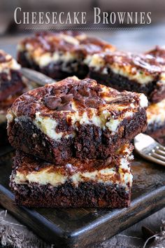 three chocolate cheesecake brownies stacked on top of each other next to a fork