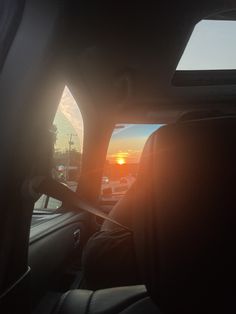 the sun is setting in the distance as seen from inside a car