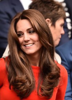 the duke and duchess of cambridge smile as they sit next to each other at an event