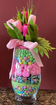 a glass vase filled with candy and flowers