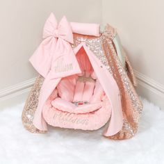 a pink and gold baby's carriage with a name on the front in glitter