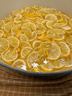 a dish filled with lemon slices on top of a checkered cloth covered tablecloth