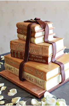 a cake made to look like books stacked on top of each other with ribbons around them