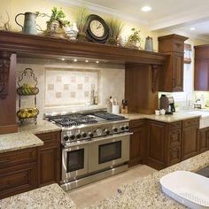 a kitchen with granite counter tops and wooden cabinets, along with stainless steel stove top oven