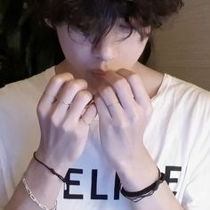 a person wearing a white shirt and some bracelets