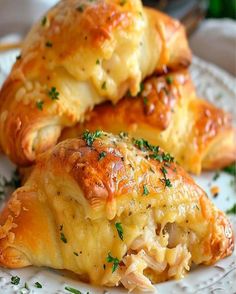 two cheesy pastries on a white plate with parsley sprinkled