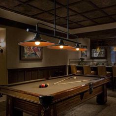 a pool table with lights hanging from it