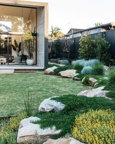 an outdoor area with grass, rocks and plants