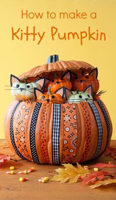 two cats sitting in a pumpkin shaped basket on top of a wooden table with autumn leaves