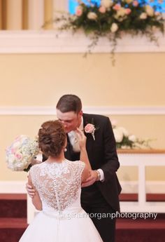 a bride and groom sharing a kiss in front of the alter at their wedding ceremony