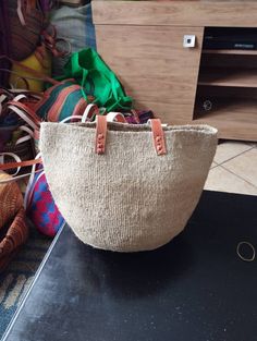 "Beige sisal tote bag DIMENSIONS Bottom width: 10\"/25.5cm Top width: 14\"/35.56cm Depth: 10\"/25.5cm Straps: 15\"/38cm SHIPPING All orders ship via DHL Express (3-5) days delivery time." Market Tote Bag With Rolled Handles, Handwoven Tote Bucket Bag, Large Capacity Jute Bucket Bag, Large Natural Color Shoulder Bag With Large Capacity, Handwoven Jute Bucket Bag Tote, Handwoven Jute Bucket Bag For Shopping, Handwoven Tote Bucket Bag For Shopping, Handwoven Jute Bucket Tote Bag, Jute Bucket Bag For Market