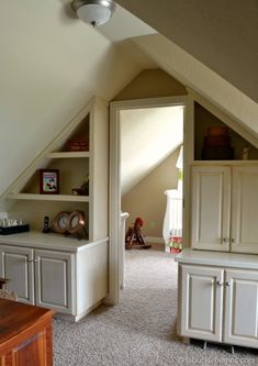 an attic bedroom with built in bookshelves and cabinets