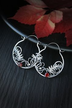 ITEM DESCRIPTION: Size H 6 x W 4 cm (2 1/2 x 1 1/2 inches) with closure. Wire earrings are very lightweight and comfortable for your ears. Weight - 5 g of each other. These unique circle earrings look like a piece of wild magic forest with fern leaves and dragonflies. I made them of sterling silver, natural garnet, and tiny labradorite. Statement botanical earrings will come to you in a gift box - ready for gifting. You can order these unique hoop earrings this different stones. Please write to Handmade Silver Botanical Earrings, Handmade Leaf-shaped Botanical Jewelry, Silver Nature-inspired Hoop Earrings As Gift, Silver Nature-inspired Hoop Earrings For Gift, Handmade Leaf-shaped Metal Earrings, Handmade Small Hoop Earrings Nature-inspired, Handmade Small Hoop Nature-inspired Earrings, Handmade Small Hoop Earrings, Nature-inspired, Handmade Metal Leaf-shaped Earrings