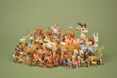 a group of deer figurines sitting next to each other on a green surface