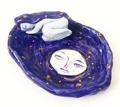 a ceramic sculpture with a sleeping baby in the middle of it's body and stars on its head