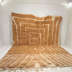 a large brown rug on display in a white room