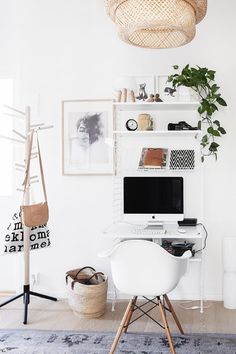 a white desk with a computer on top of it next to a potted plant