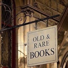 an old and rare book store sign hanging off the side of a building