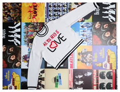 a white long sleeved shirt with the words all you need is love printed on it