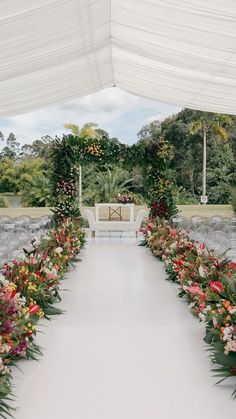 an outdoor ceremony setup with flowers and greenery