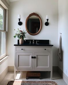 a bathroom with a sink, mirror and rug