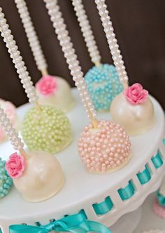 cake pops decorated with pearls and flowers on a table