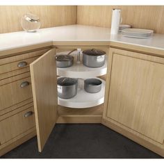 a kitchen corner with pots and pans on the counter top in front of wooden cabinets