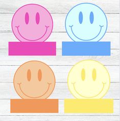 three smiley faces sitting on top of each other in front of a white wooden background