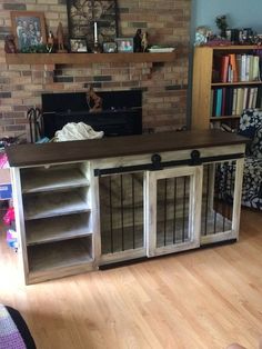 a living room filled with furniture and a fire place next to a book shelf on top of a hard wood floor