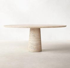 a round table made out of concrete sitting on top of a white floored room