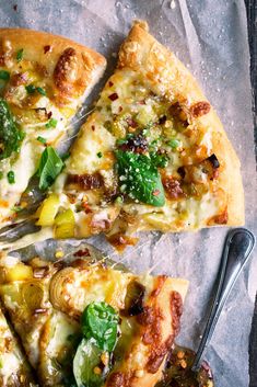 a slice of pizza on top of a piece of paper with a knife and fork