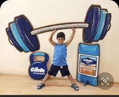 a young boy standing in front of a giant sign with a barbell on it