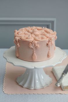 a pink cake sitting on top of a white plate