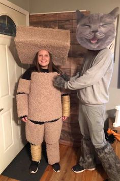 two people in costumes standing next to each other, one wearing a cat costume and the other holding a cardboard box