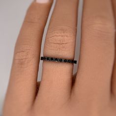 a woman's hand with a black diamond ring on it