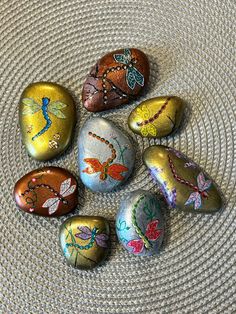 six painted rocks sitting on top of a table