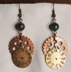 two earrings with gears and beads hanging from them