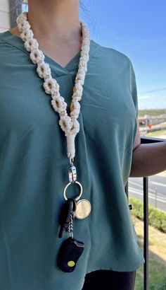 a woman wearing a necklace with two keys attached to it