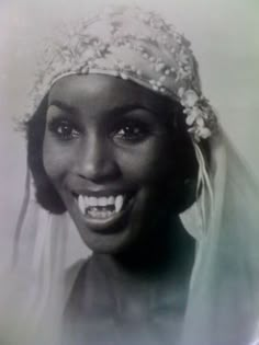 a black and white photo of a woman wearing a veil