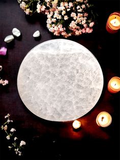 a table with candles and some flowers on it, next to a plate that is covered in ice