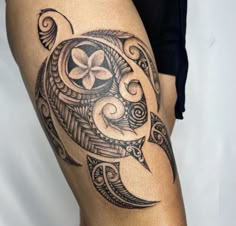 a close up of a person's leg with a tattoo design on the thigh