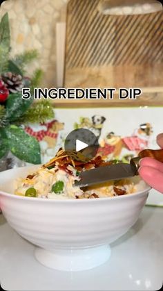 a bowl filled with food on top of a counter next to a knife and fork