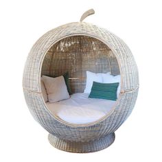 a bed made out of wicker with pillows on it