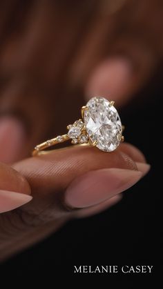 a close up of a person's hand holding an engagement ring