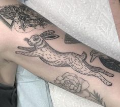 a person with a tattoo on their arm that has a rabbit in the middle of it